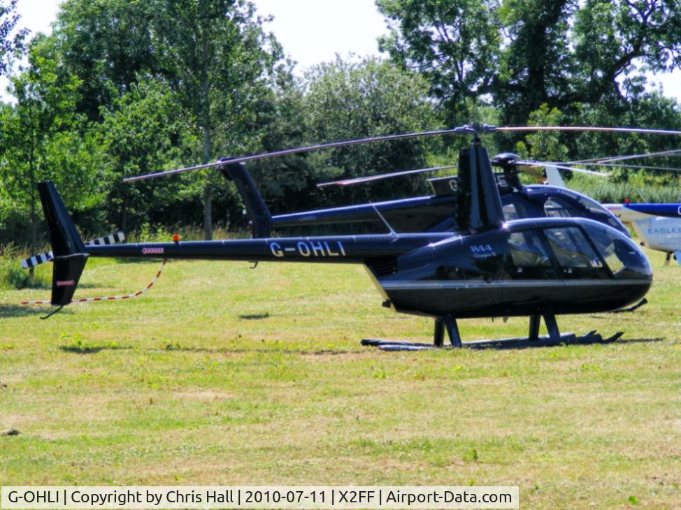 G-OHLI, 2005 Robinson R44 Clipper II C/N 10832, Robinson R44 being used for ferrying race fans to Silverstone for the British Grand Prix from this temporary heliport a few miles east of Bicester