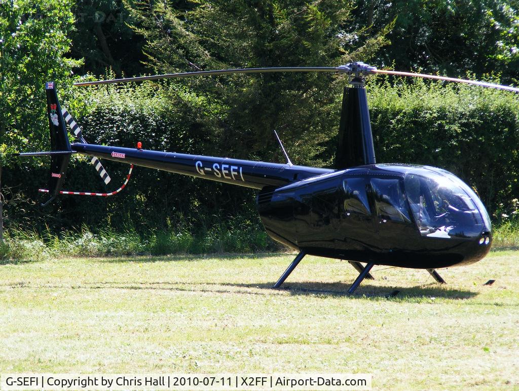 G-SEFI, 2003 Robinson R44 Raven II C/N 10147, Robinson R44 being used for ferrying race fans to Silverstone for the British Grand Prix from this temporary heliport a few miles east of Bicester
