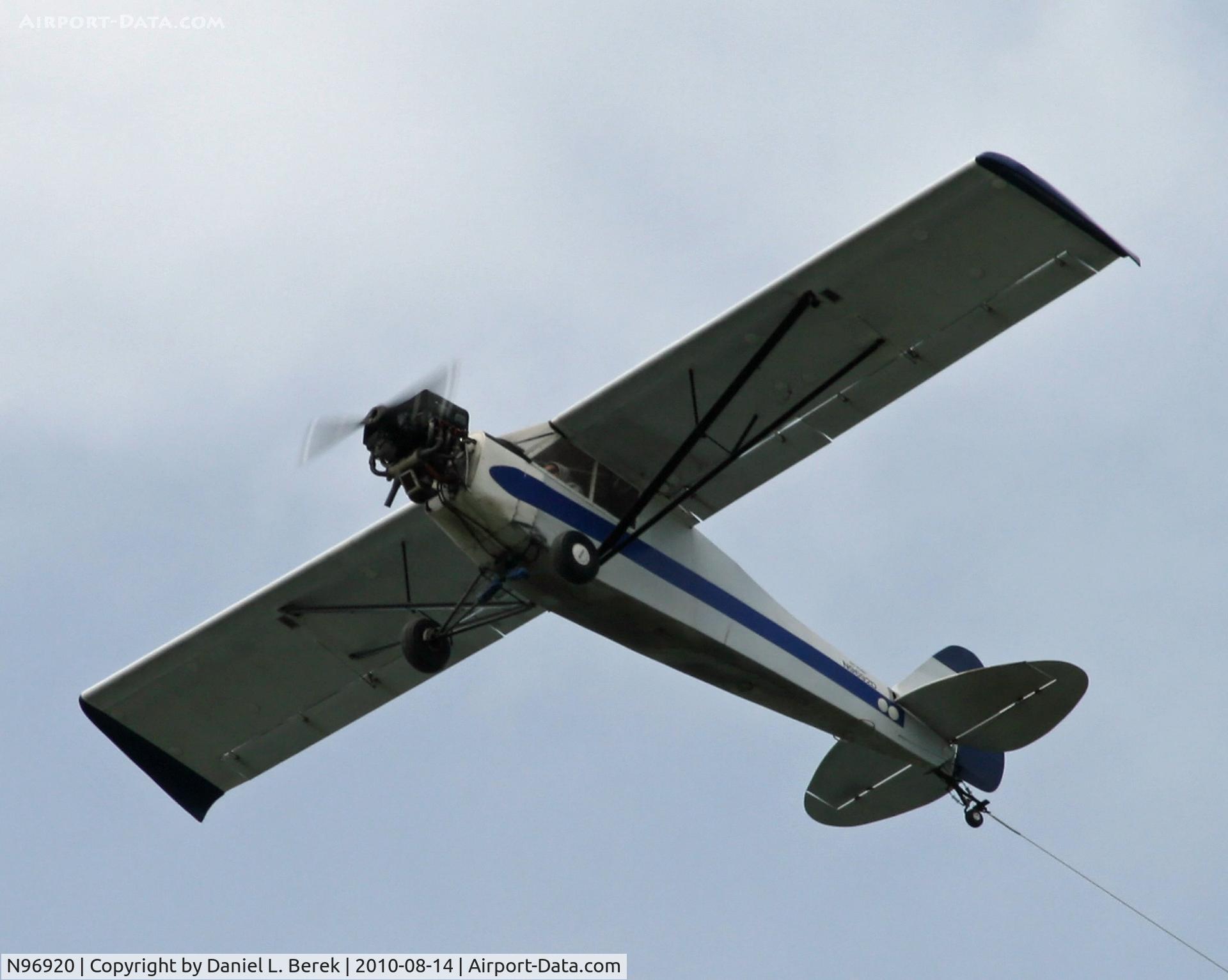 N96920, 1946 Taylorcraft BC12-D C/N 9220, An old Taylorcraft struggles against the wind as it tows a giant banner over Cape Cod.