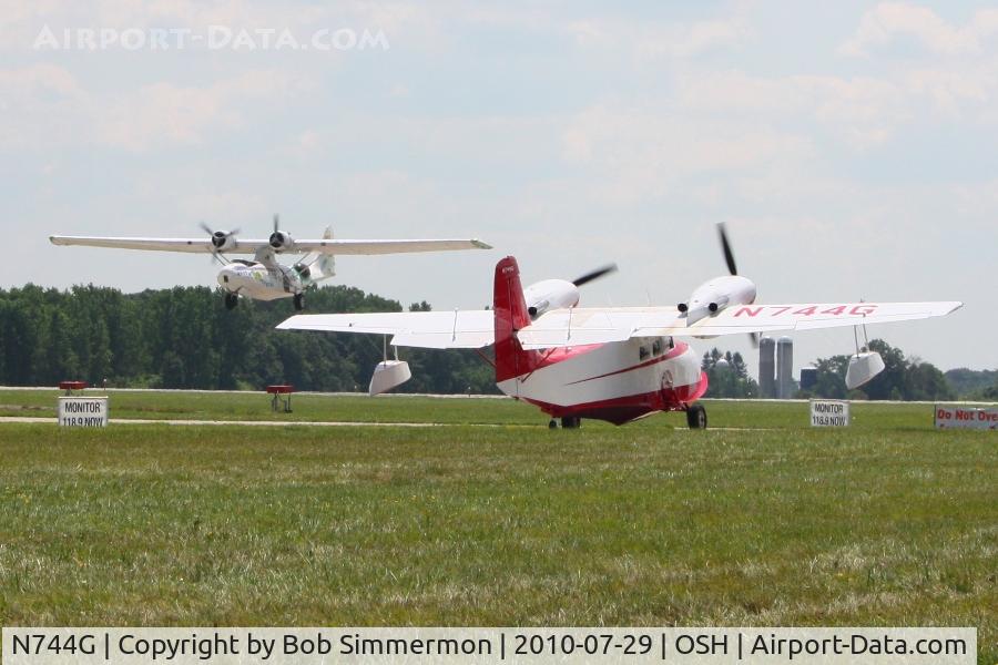 N744G, 1944 Grumman G-44 Widgeon C/N 1394, Airventure 2010 - Oshkosh, Wisconsin, with N222FT landing in the background.