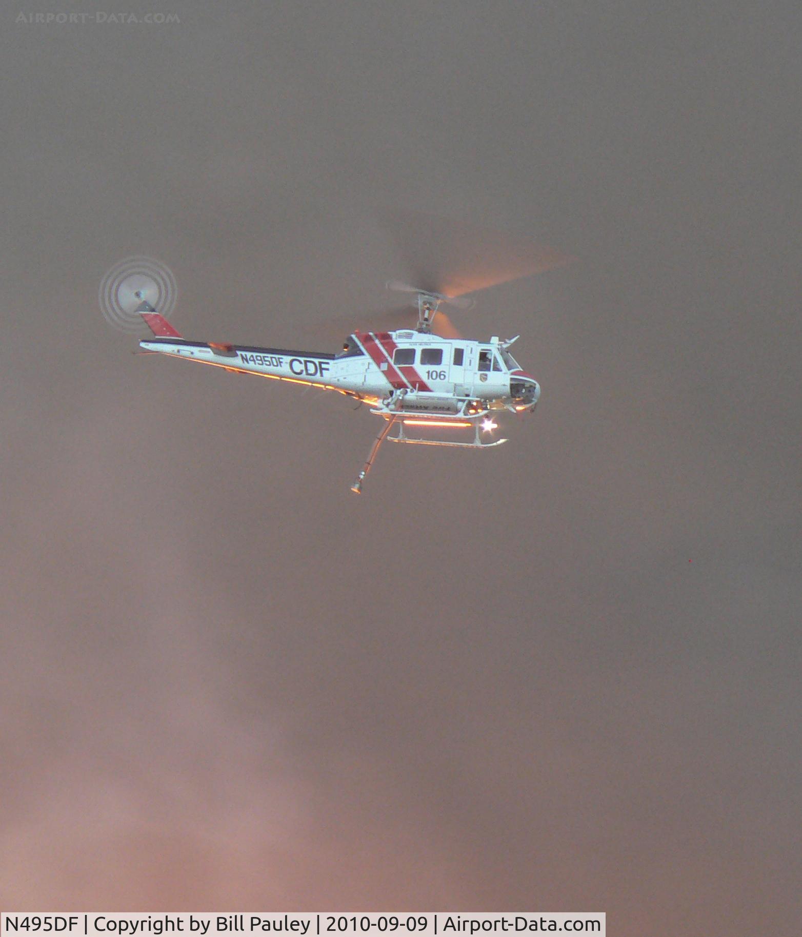N495DF, Bell EH-1H C/N 12218, Taken at 7:20:42 PM, 9/9/10 above San Bruno, CA, site of massive natural gas pipeline explosion. The undercarriage is lit orange from the light of the intense fire below.