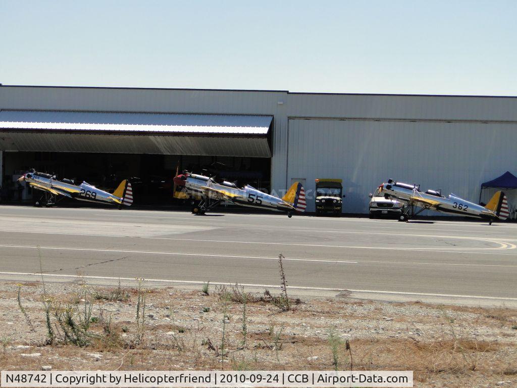 N48742, 1941 Ryan Aeronautical ST3KR C/N 1298, N48742, N46234, N56026 parked by a hanger for dispaly