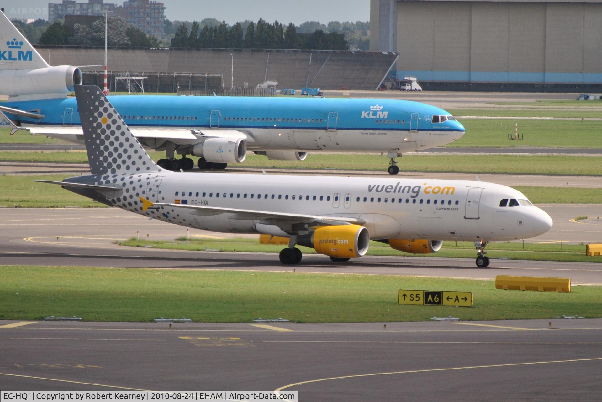 EC-HQI, 2001 Airbus A320-214 C/N 1396, Vueling taxiing in after arrival while a heavy KLM departs
