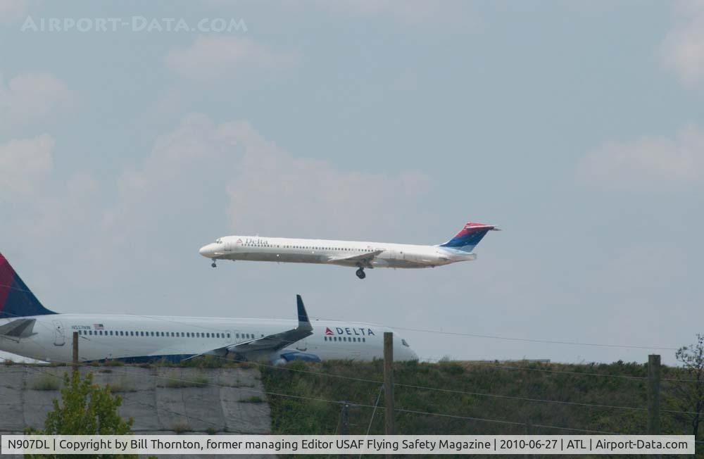 N907DL, 1987 McDonnell Douglas MD-88 C/N 49538, A Delta Boeing MD-88 over the numbers for Rwy 27R@ATL as a Delta Boeing 757-251, N557NW holds #1 for departure. The B757 once wore NW Airlines livery colors.  (an f-stop 5.6 photograph)