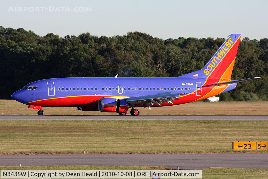 N343SW, 1989 Boeing 737-3H4 C/N 24151, Southwest Airlines N343SW (FLT SWA1384) rolling out on RWY 5 after arrival from Orlando Int'l (KMCO). The Airport Operations truck in the background is trying to rid the area of flocks of seagulls (non-lethal methods) that are posing a threat to aircraft.