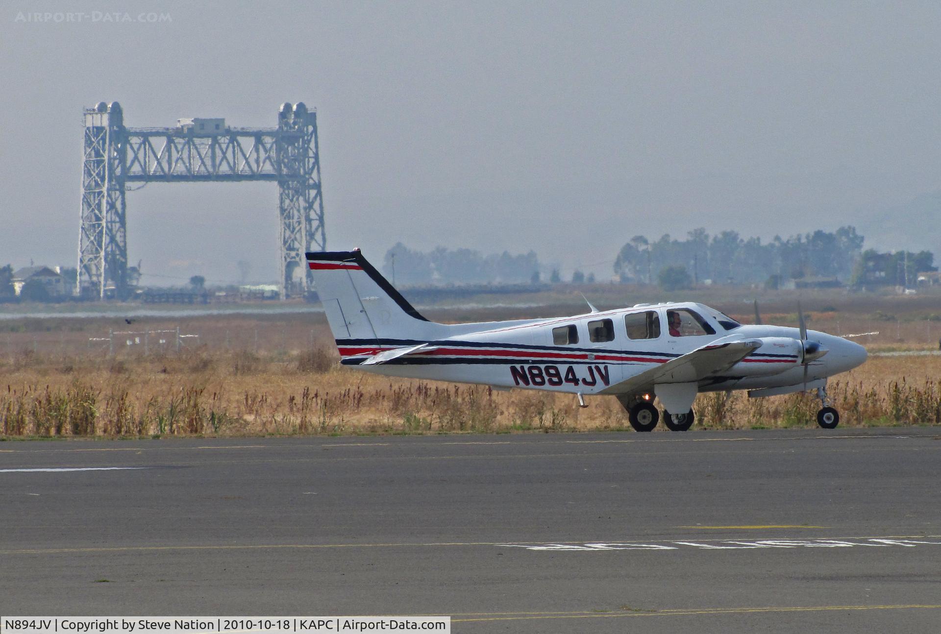 N894JV, Hawker Beechcraft Corp G58 Baron C/N TH-2268, Framed by the historic Napa River RR Bridge this former JAL 2009 Hawker Beechcraft G58 taxis back to IASCO ramp after one of last training flights for the Japanese airline