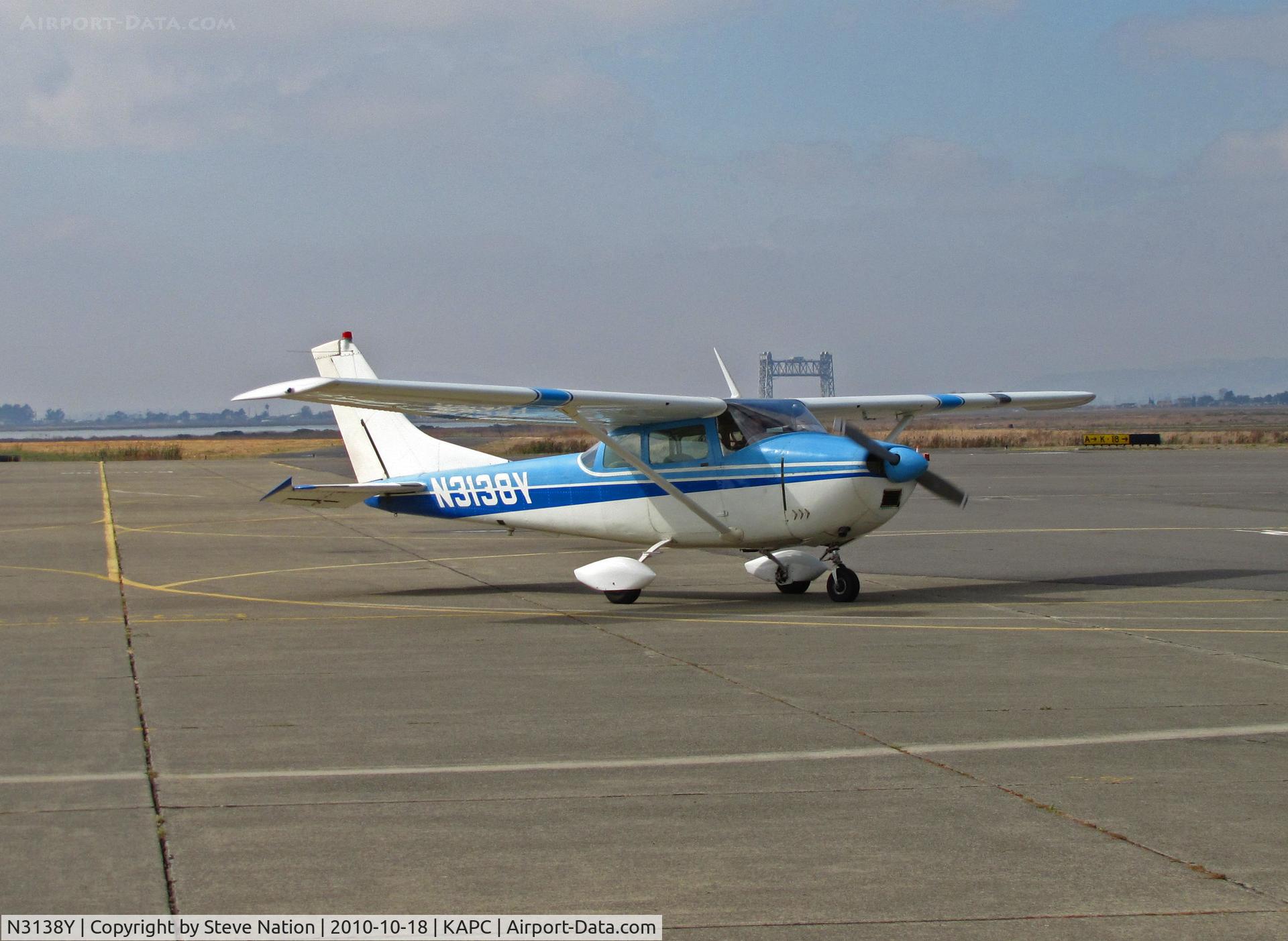N3138Y, 1962 Cessna 182E Skylane C/N 18254138, 1962 Cessna 182E taxis to gas stand at Napa, CA home base - Napa River RR Bridge in background