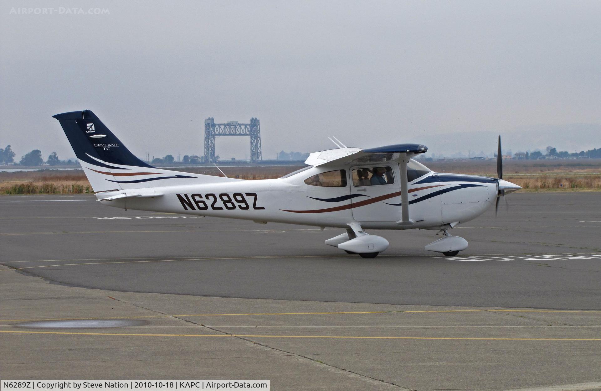 N6289Z, Cessna T182T Turbo Skylane C/N T18208870, 2008 Cessna T182T taxis to visitors ramp @ Napa, CA - Historic Napa River RR Bridge landmark in background
