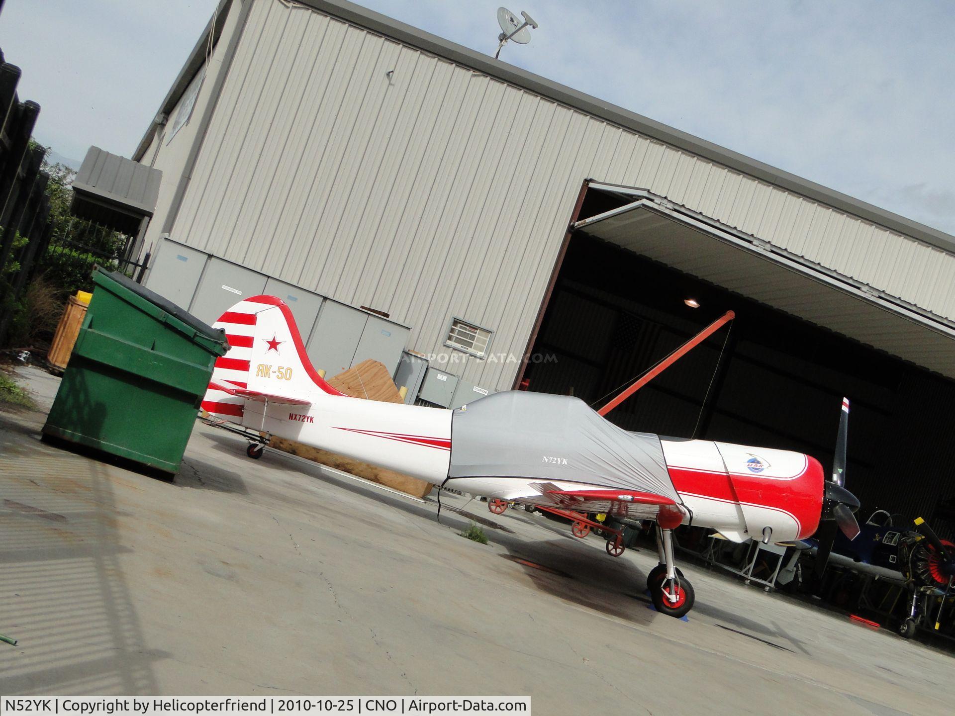 N52YK, 1989 Yakovlev Yak-52 C/N 8910007, Parked next to the hanger with it's canopy covered to protect it from the weather