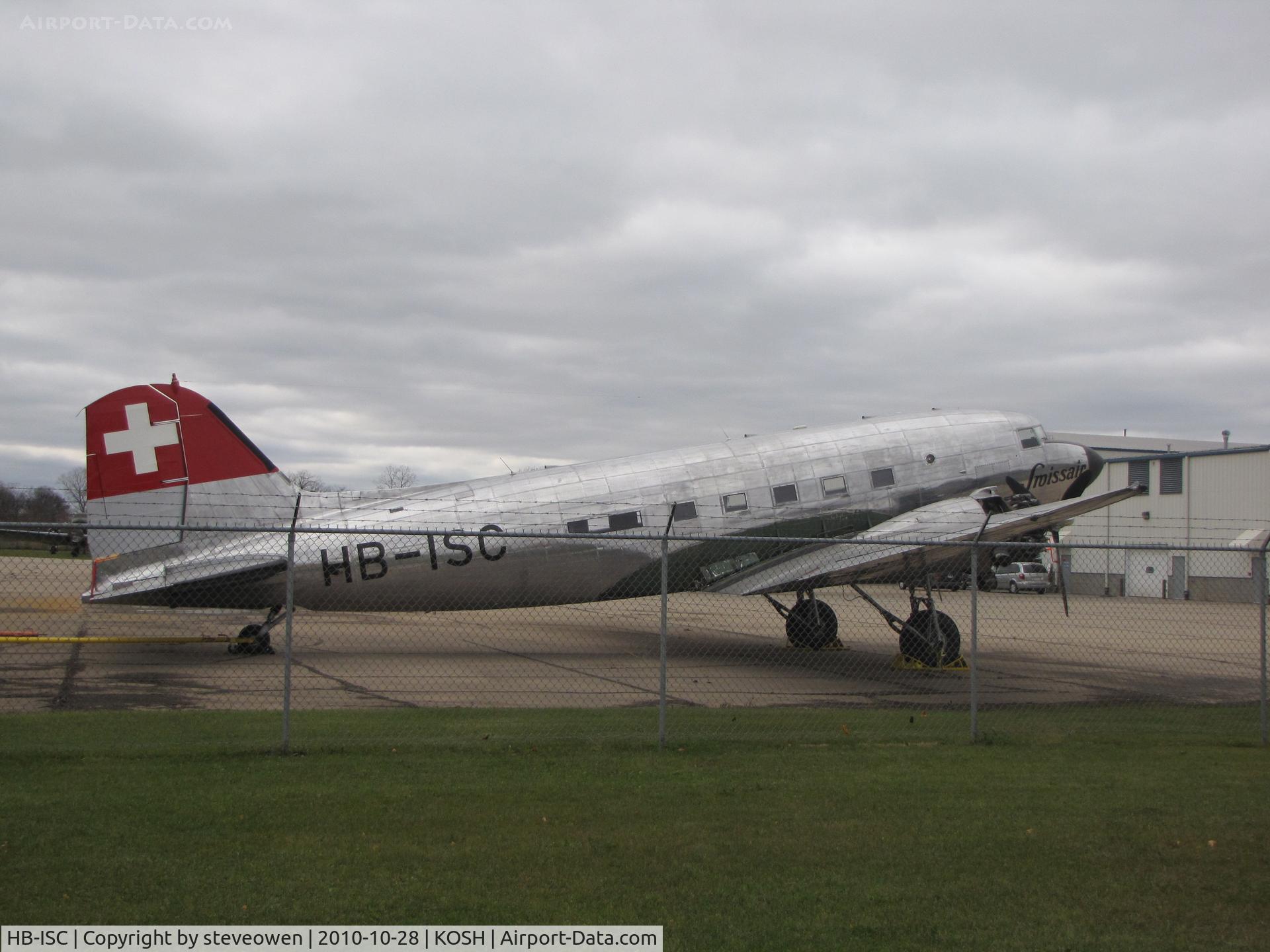 HB-ISC, 1943 Douglas DC-3C-S1C3G (C-47A) C/N 9995, At Basler Turbo Conversions Oshkosh WI USA.Thru the fence shot