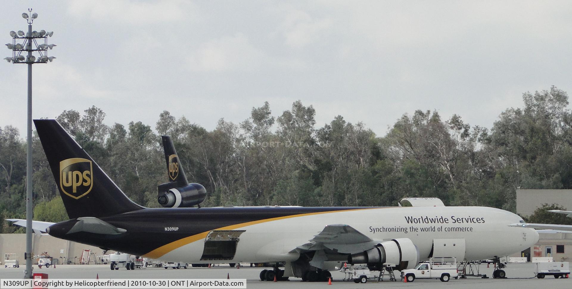 N309UP, 1996 Boeing 767-34AF C/N 27740, Parked in UPS parking apron area, appears to be loading