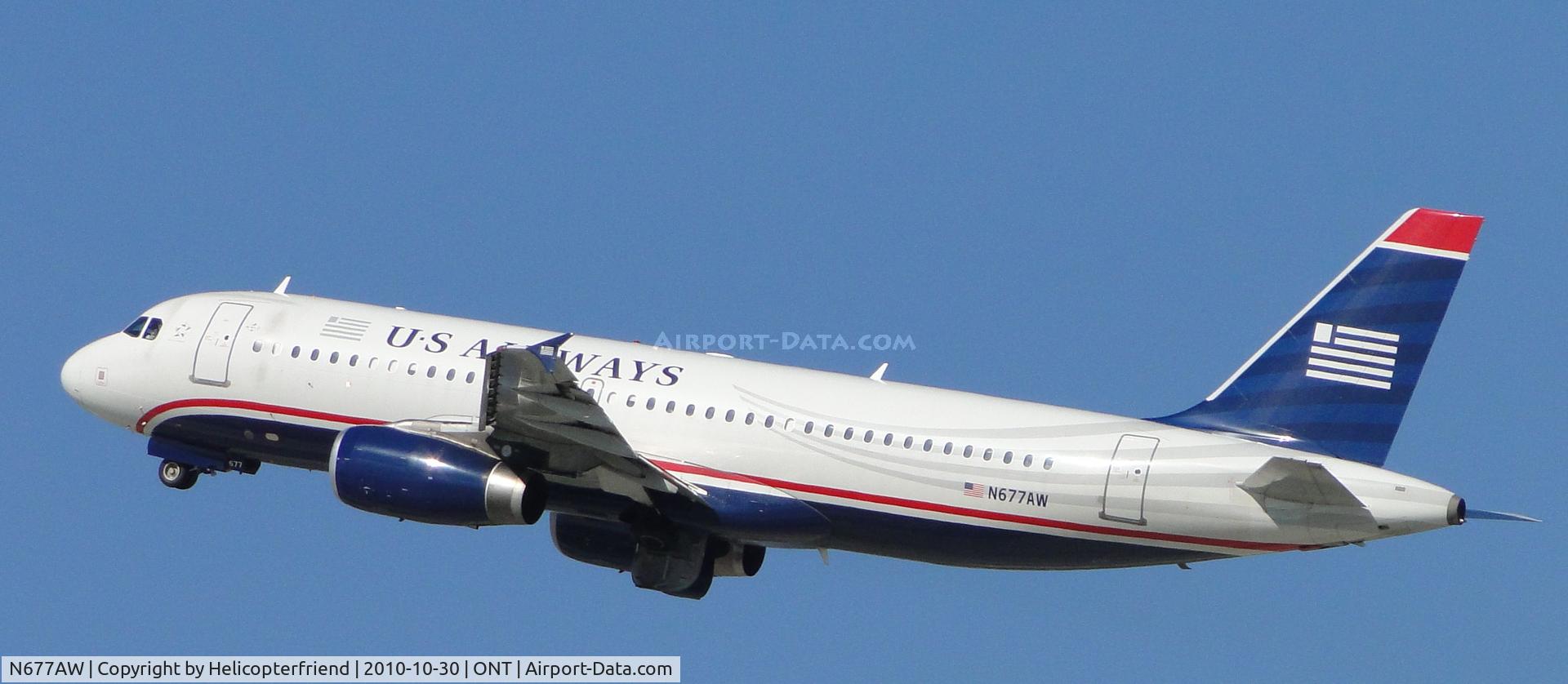 N677AW, 2005 Airbus A320-232 C/N 2430, Wheels coming up and ship climbing out after take off from runway 26R