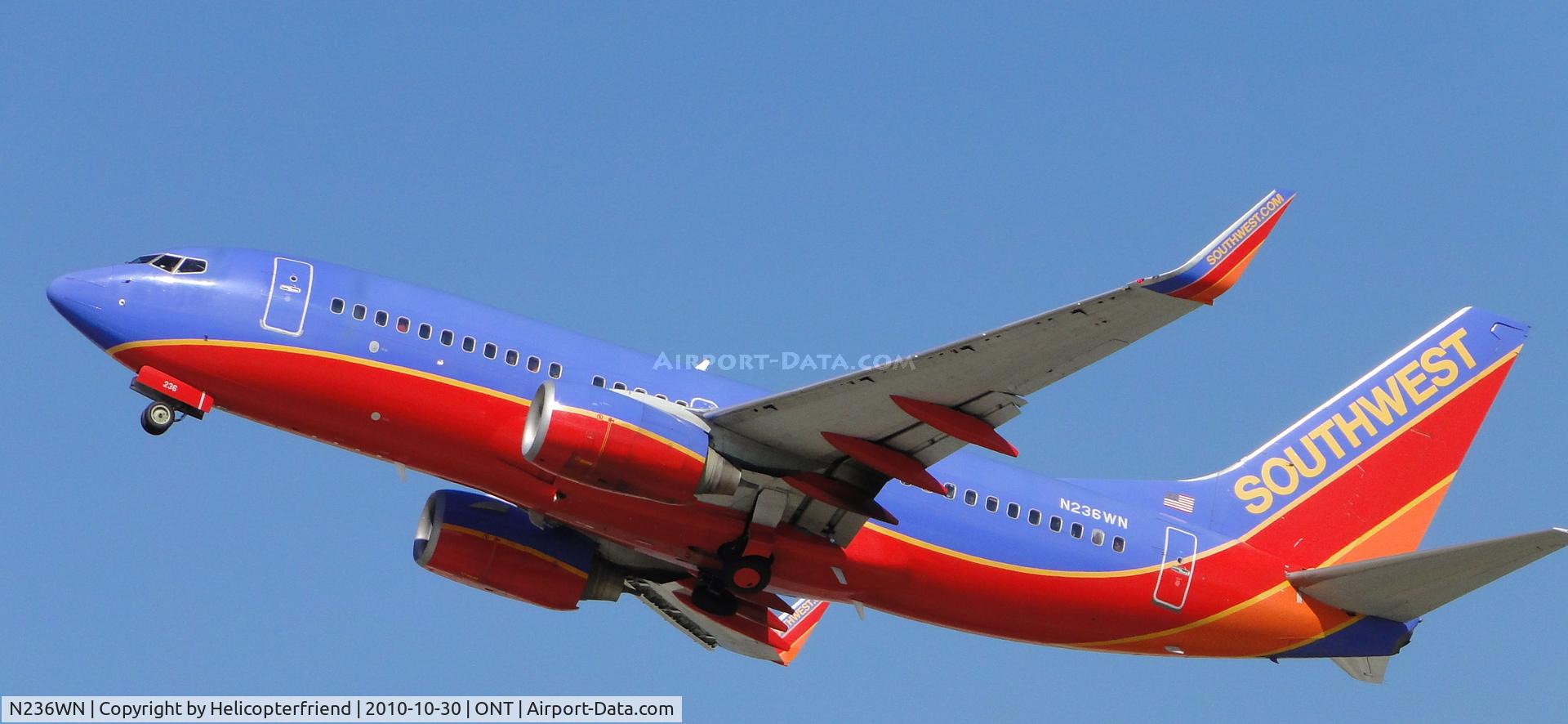 N236WN, 2006 Boeing 737-7H4 C/N 34631, Wheels coming up, heading westbound after taking off from runway 26R
