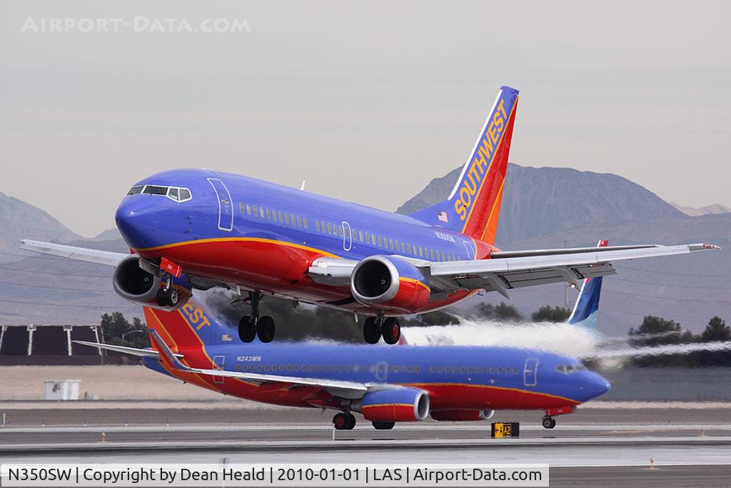 N350SW, 1989 Boeing 737-3H4 C/N 24409, Southwest Airlines N350SW landing RWY 25L, while Southwest Airlines N243WN holds short, and Delta Air Lines N840MH holds in position on RWY 25R.