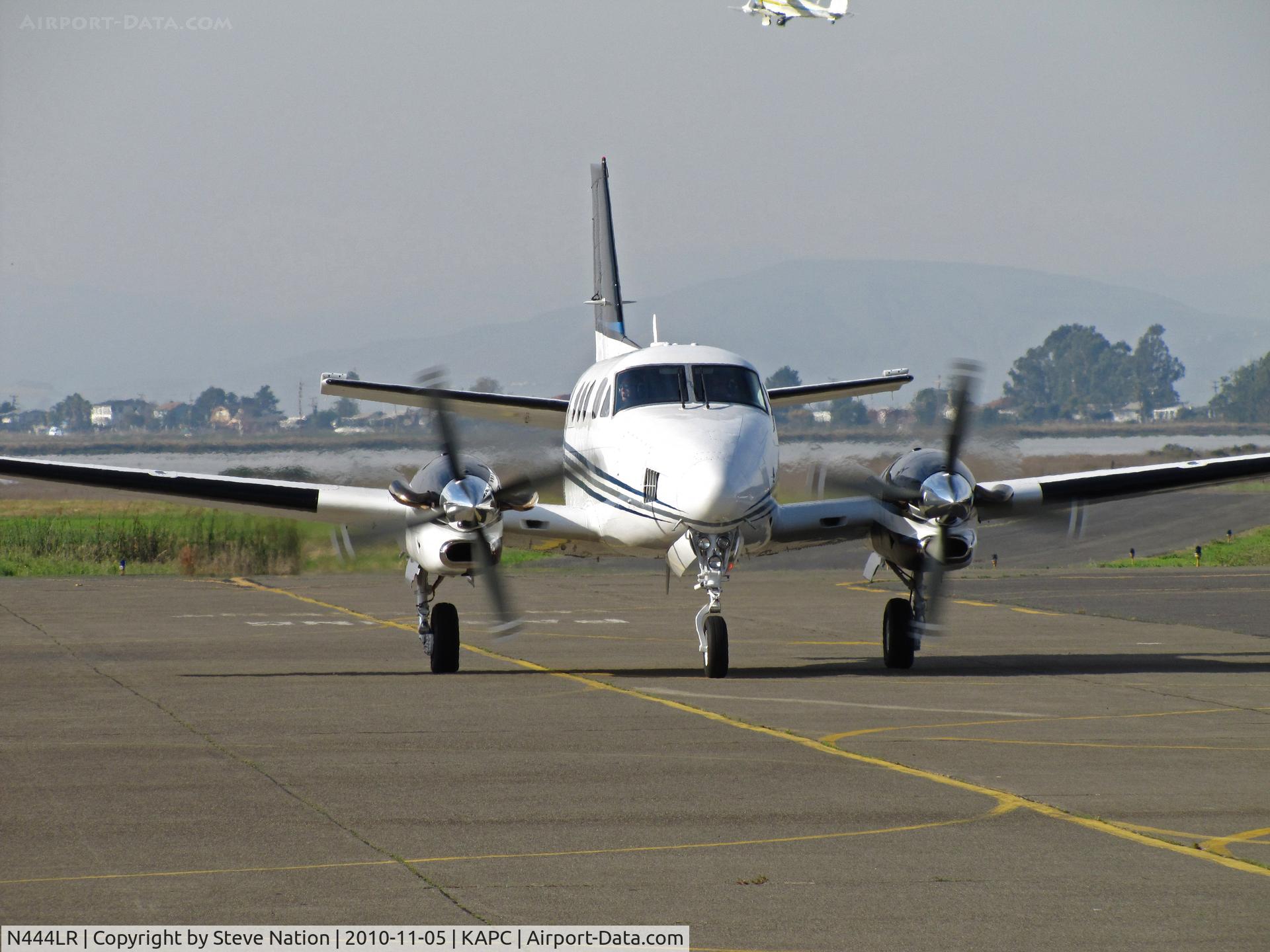 N444LR, 1996 Beech C90A King Air C/N LJ-1447, Head-on shot of N444LR LLC (Malibu, CA) 1996 Beech C90A King Air arriving from KCMA/Camarillo, CA with Staggerwing N9115H climbing out in background