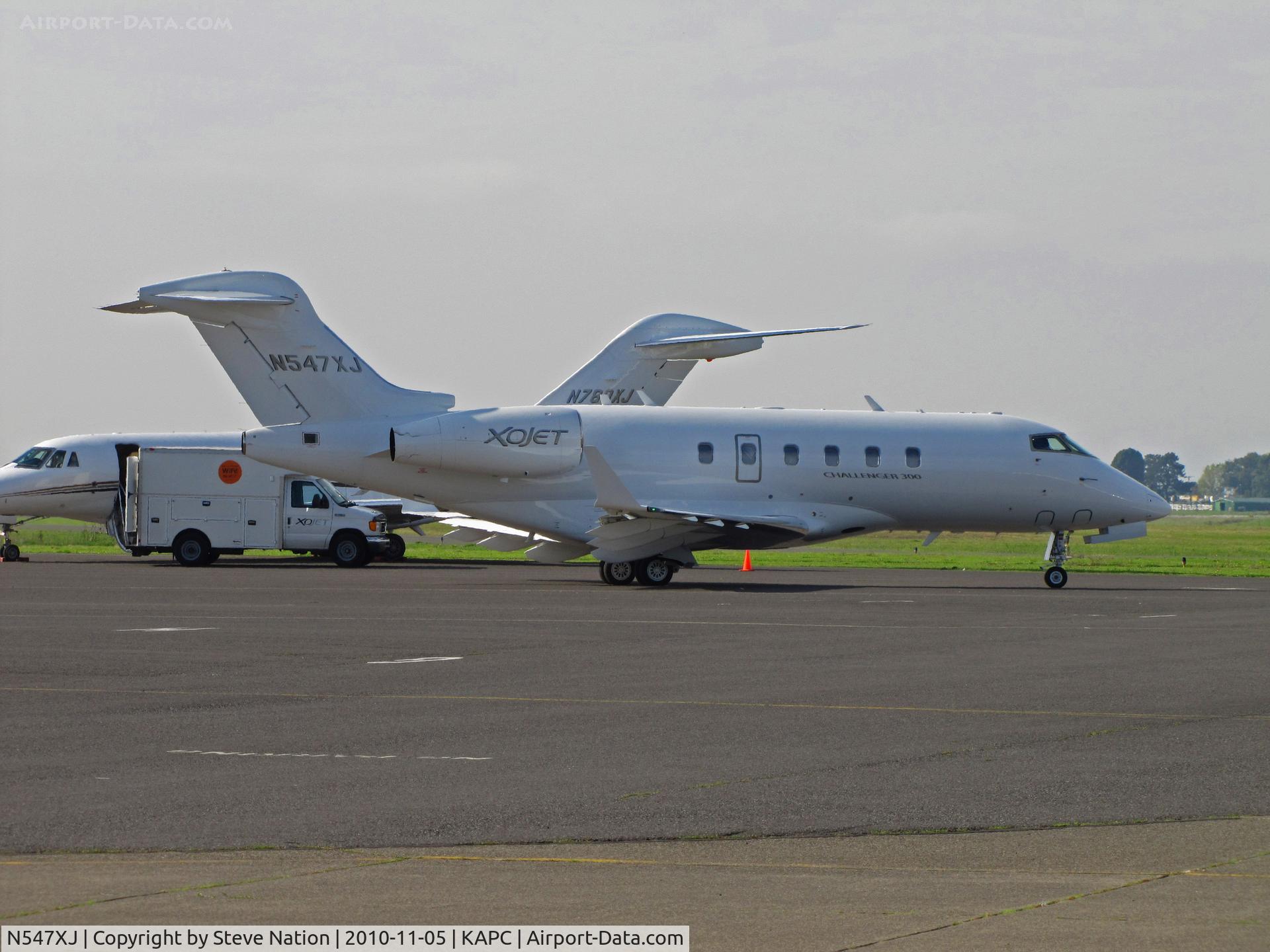 N547XJ, 2009 Bombardier Challenger 300 (BD-100-1A10) C/N 20281, XOJET 2009 Challenger BD-100-1A10 taxis past sister ship (XOJET 2007 Cessna 750 N780XJ) on departure to KTEB/Teterboro, NJ