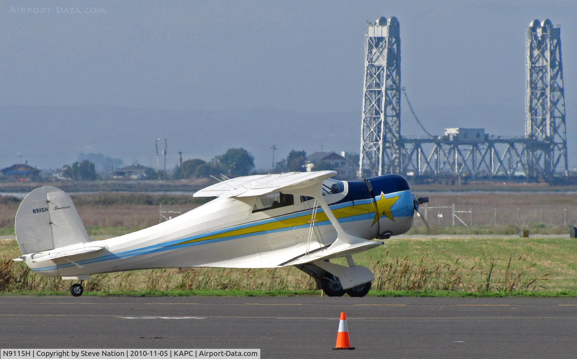 N9115H, 1941 Beech D17S Staggerwing C/N 1014, Locally-based 1941 Beech D17S taxis for some morning sun and a few touch-and-gos @ Napa County Airport, CA - historic Napa River RR Bridge in background