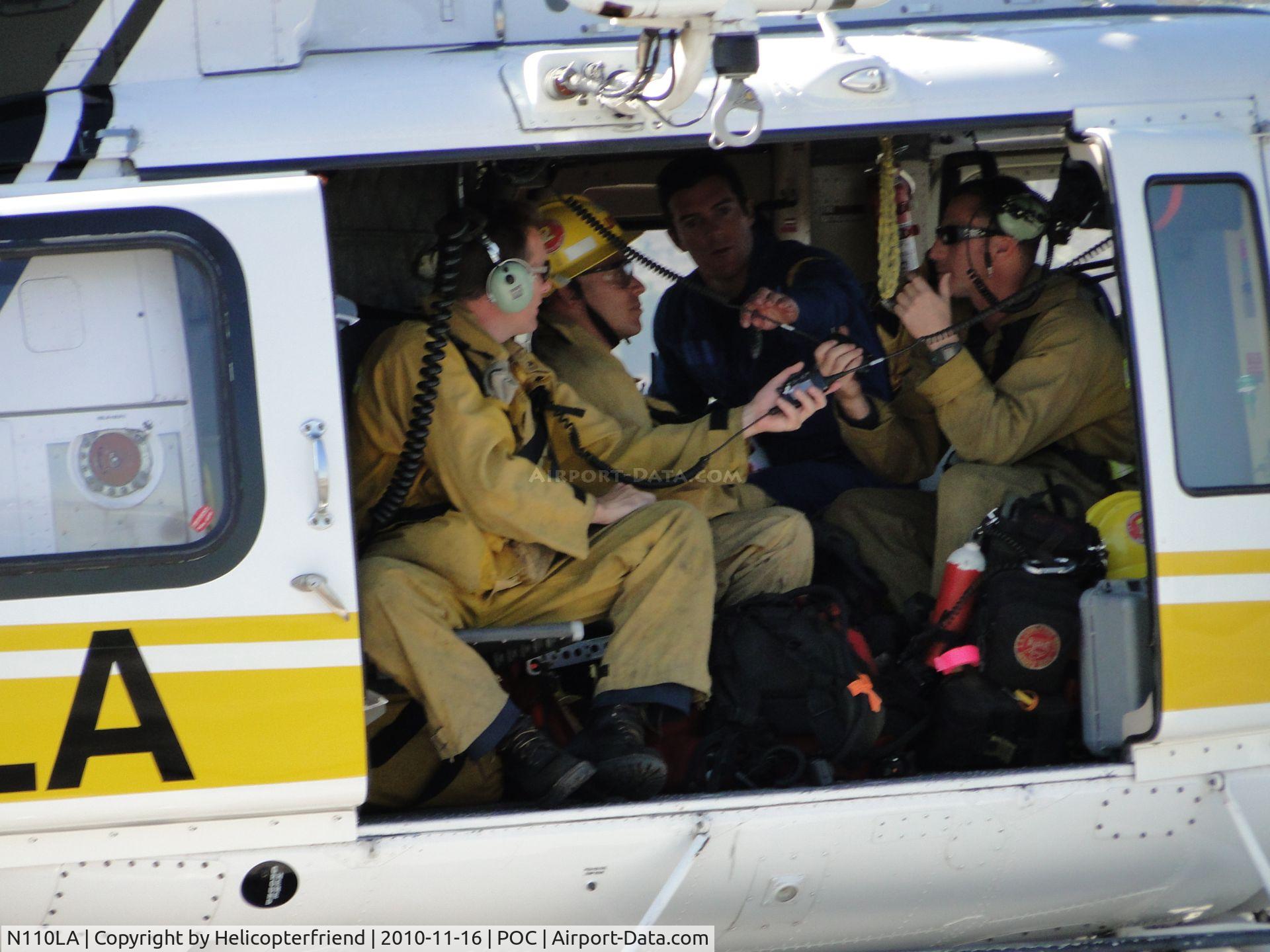 N110LA, 2005 Bell 412EP C/N 36392, Helicopter crew member showing firefighters how to use the radio