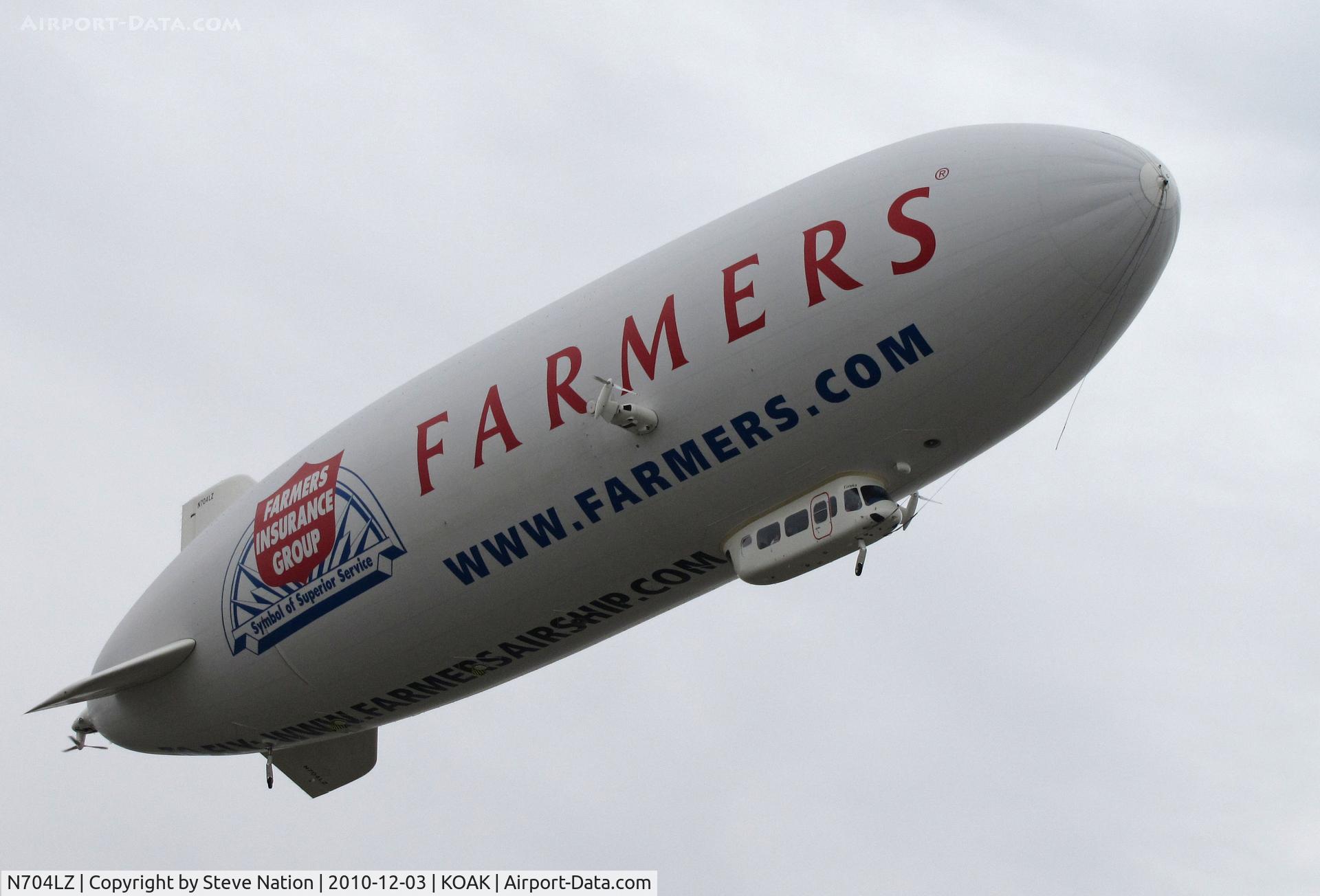 N704LZ, 2008 Zeppelin LZ N07-100 C/N 004, Airship Ventures dirigible in latest color scheme (Farmer's Insurance titles) climbing out from North Field @ Oakland International Airport, CA
