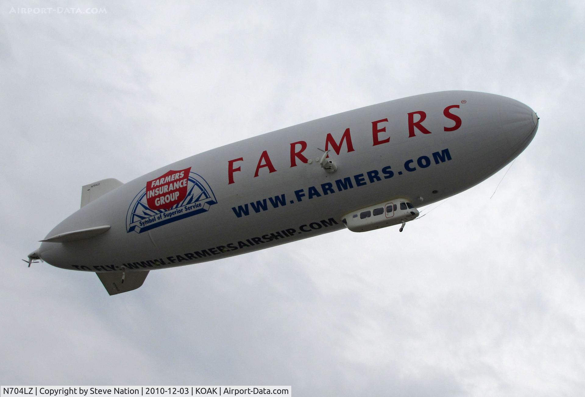 N704LZ, 2008 Zeppelin LZ N07-100 C/N 004, Airship Ventures dirigible in latest color scheme (Farmer's Insurance titles) climbing out from North Field @ Oakland International Airport, CA