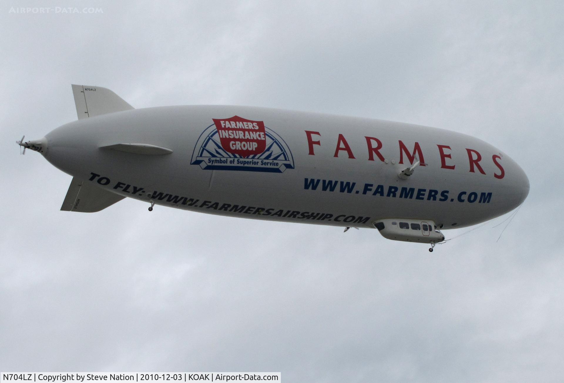 N704LZ, 2008 Zeppelin LZ N07-100 C/N 004, Airship Ventures dirigible in latest color scheme (Farmer's Insurance titles) climbing out from North Field @ Oakland International Airport, CA