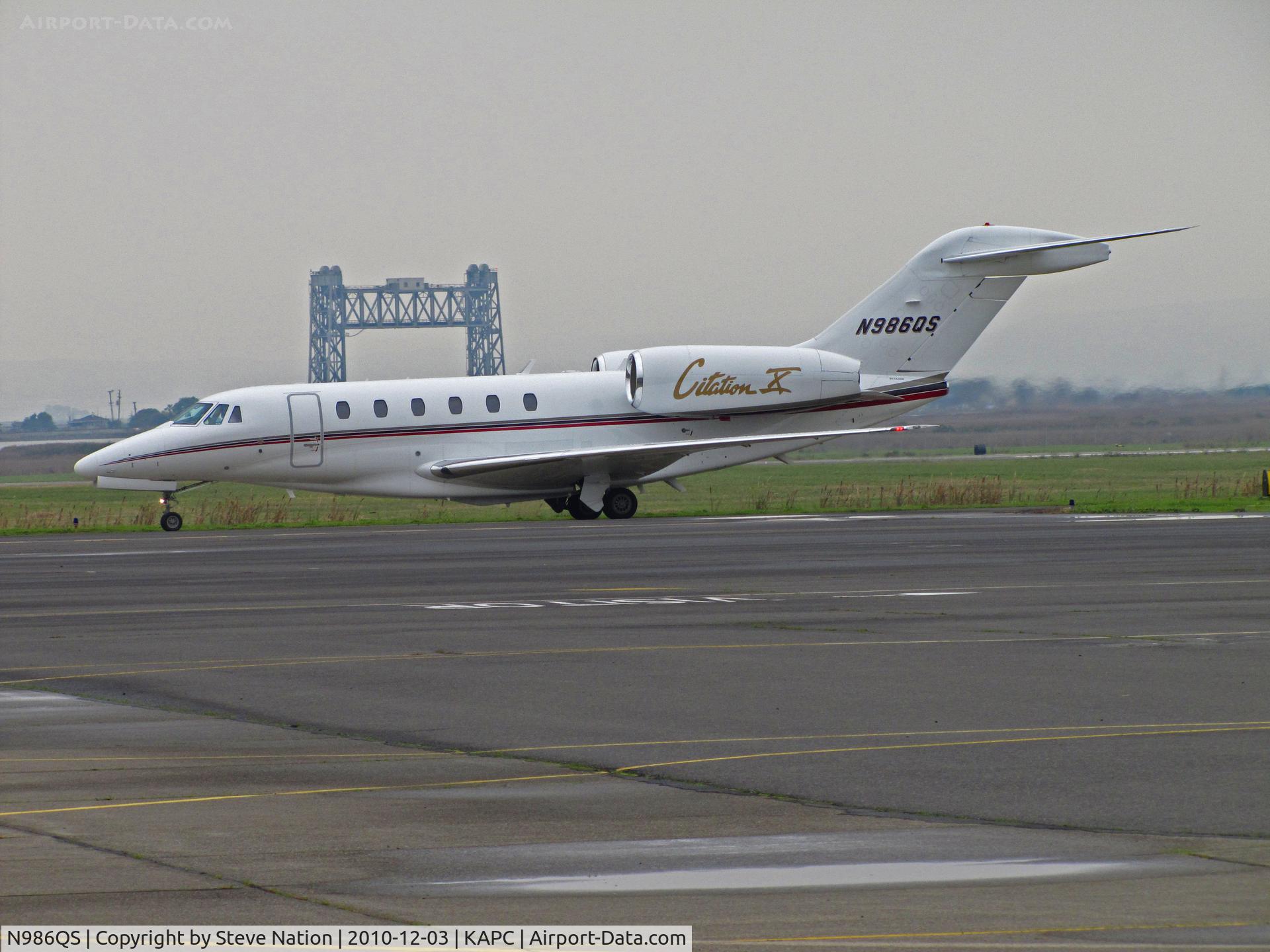N986QS, 1999 Cessna 750 Citation X C/N 750-0086, NetJets 1999 Cessna 750 returns to ramp (Napa River RR Bridge in background) with mechanical issue (?) - was going to KSMF (Sacramento Metro Airport, CA) @ Napa County Airport, CA