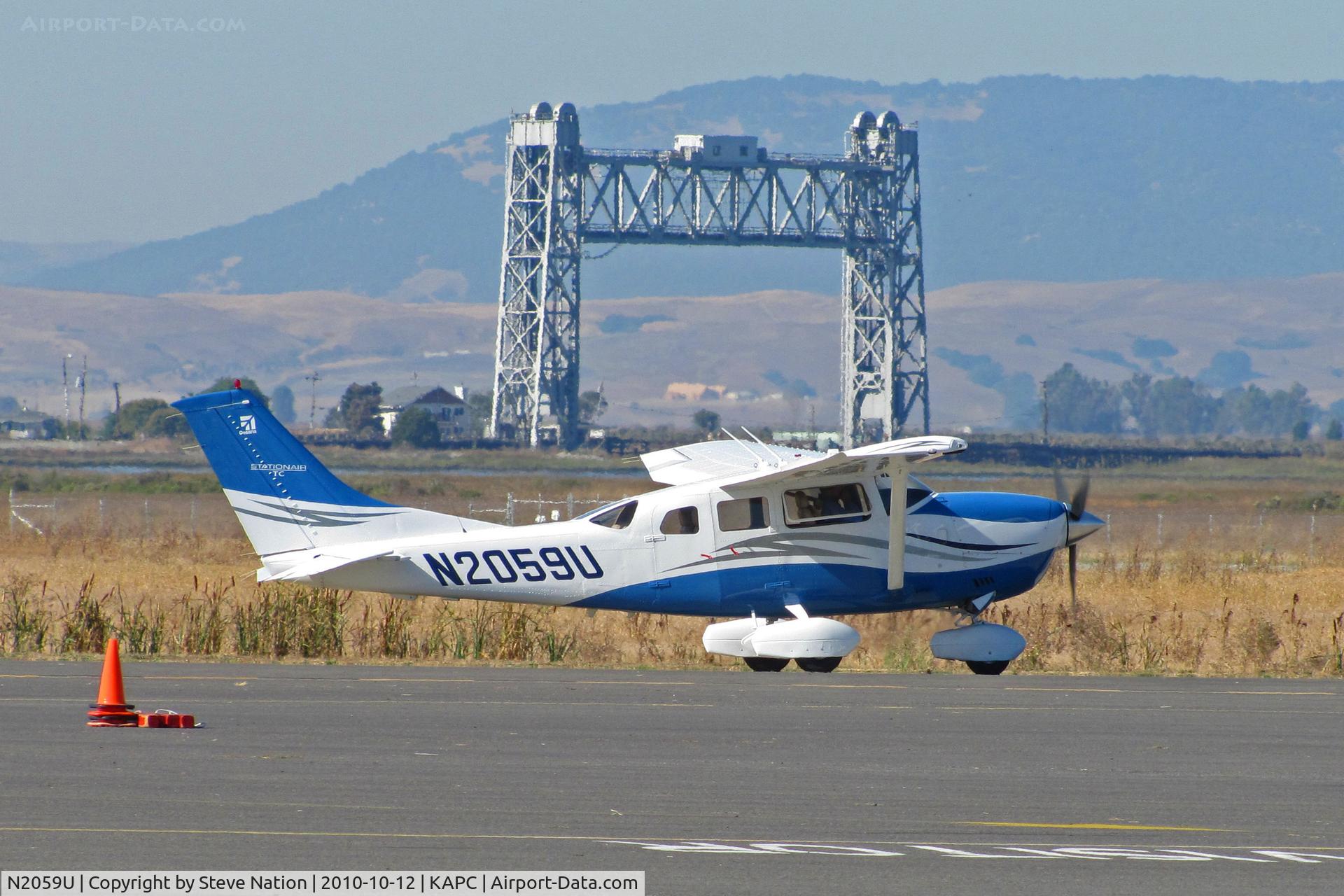 N2059U, 2006 Cessna T206H Turbo Stationair C/N T20608701, 2006 Cessna T206H taxiing with Napa River RR Bridge in background @ Napa County Airport, CA