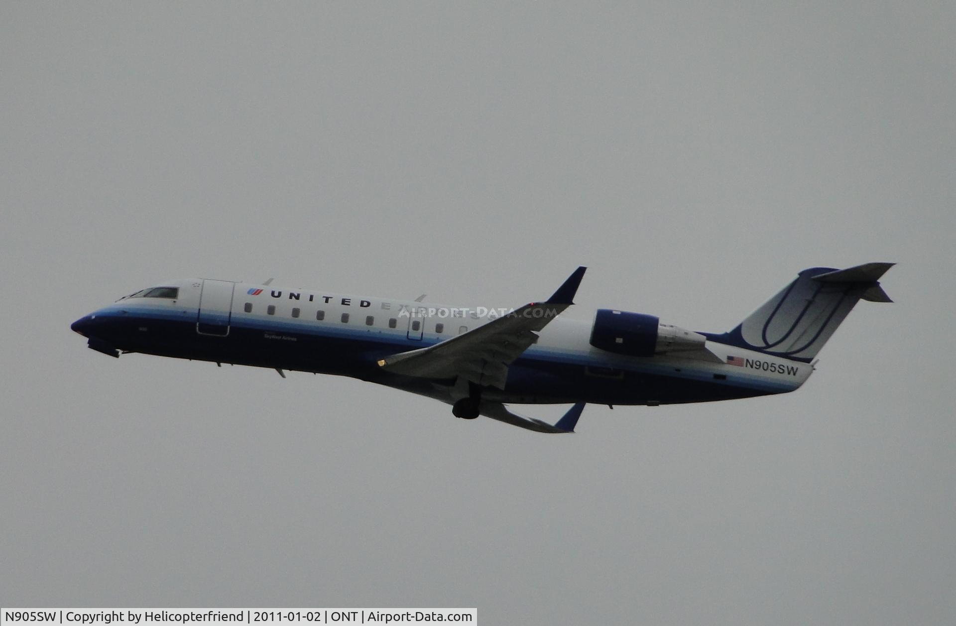 N905SW, 2000 Bombardier CRJ-200LR (CL-600-2B19) C/N 7437, Taking off westbound from runway 26R, wheels coming up