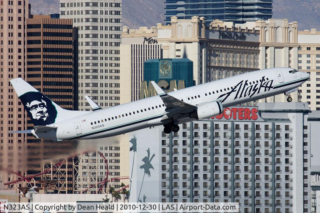 N323AS, 2004 Boeing 737-990 C/N 30021, Alaska Airlines N323AS (FLT ASA619) climbing out from RWY 1R en route Seattle-Tacoma Int'l (KSEA), with the Monte Carlo Hotel and the Hooters Hotel in the background.