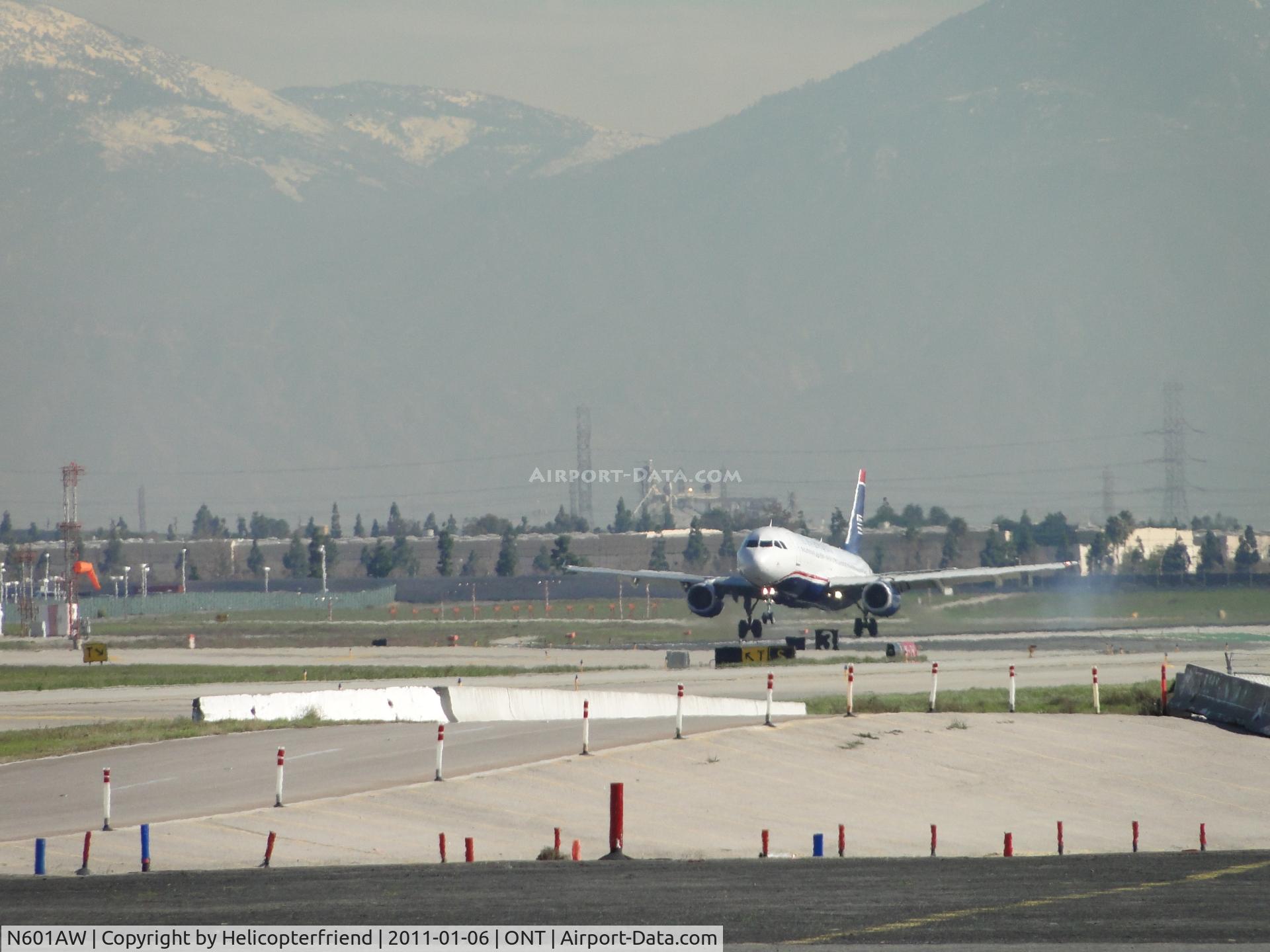 N601AW, 2003 Airbus A320-232 C/N 1935, Touching down on runway 26L, nose wheel still off the ground