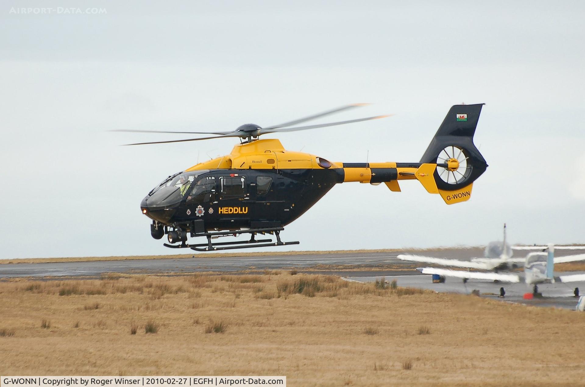 G-WONN, 2007 Eurocopter EC-135T-2+ C/N 0597, South and East Wales Police Air Support Unit helicopter (Police 32) going on patrol. Marked POLICE on the starboard side.