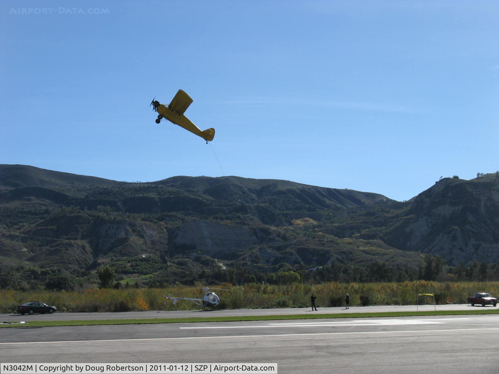 N3042M, 1947 Piper PA-12 Super Cruiser C/N 12-1734, 1947 Piper PA-12 SUPER CRUISER, Lycoming O-360 180 Hp upgrade operated uncowled (field approval), Restricted class banner tow, missed pickup again Rwy 04R grass. See pickup rig at lower right of photo.