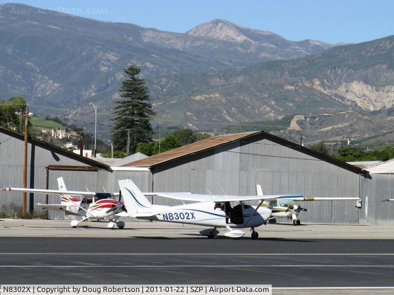 N8302X, 1961 Cessna 172C C/N 17248802, 1961 Cessna 172C, Continental O-300 145 Hp 6 cylinder, taxi to Rwy 22, passenger door removed. 6,704' Hines Peak in background