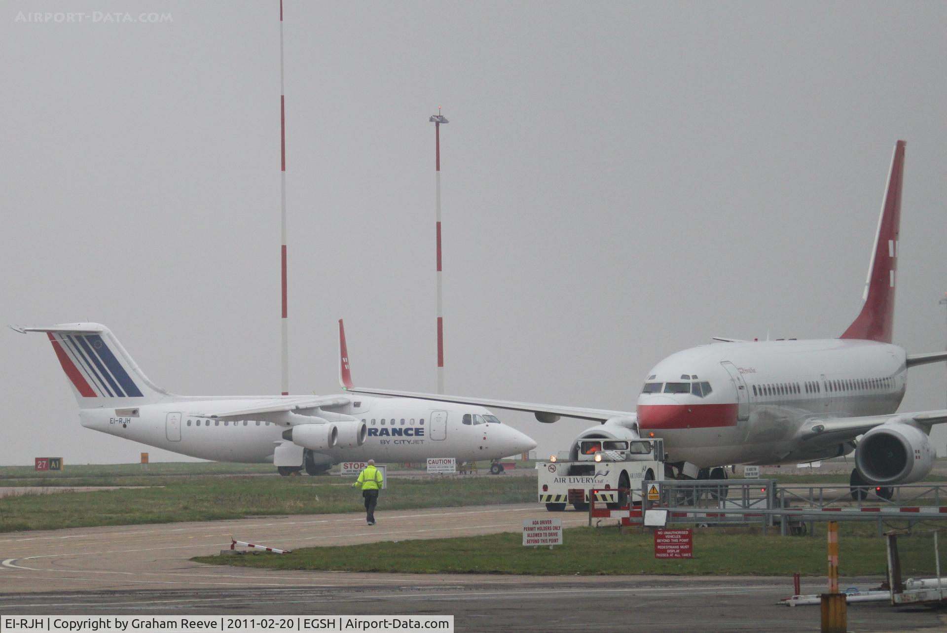 EI-RJH, 1999 BAE Systems Avro 146-RJ85 C/N E.2345, With HB-IIQ being towed past on its way for a re-spray.