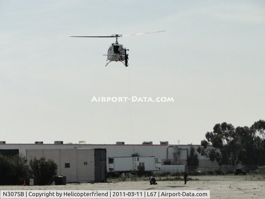 N307SB, 1975 Bell 212 C/N 30781, Deputy on skid working with 2 personnel on the ground