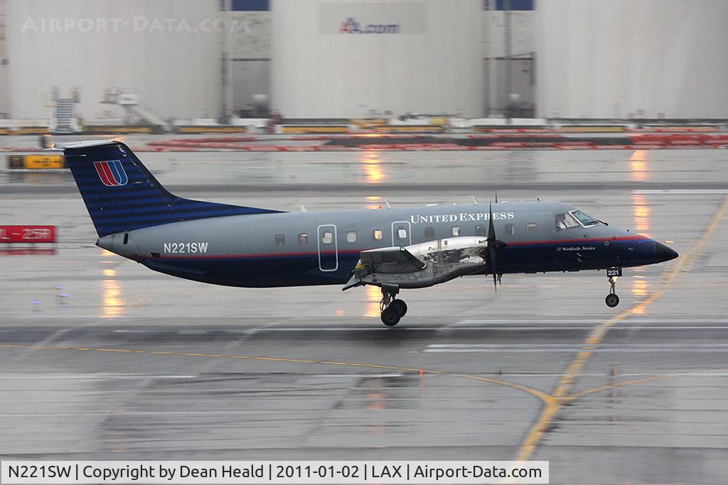 N221SW, 1994 Embraer EMB-120ER Brasilia C/N 120.290, United Express (SkyWest Airlines) N221SW landing RWY 7R. Check out the guy in the 2nd to last window.
