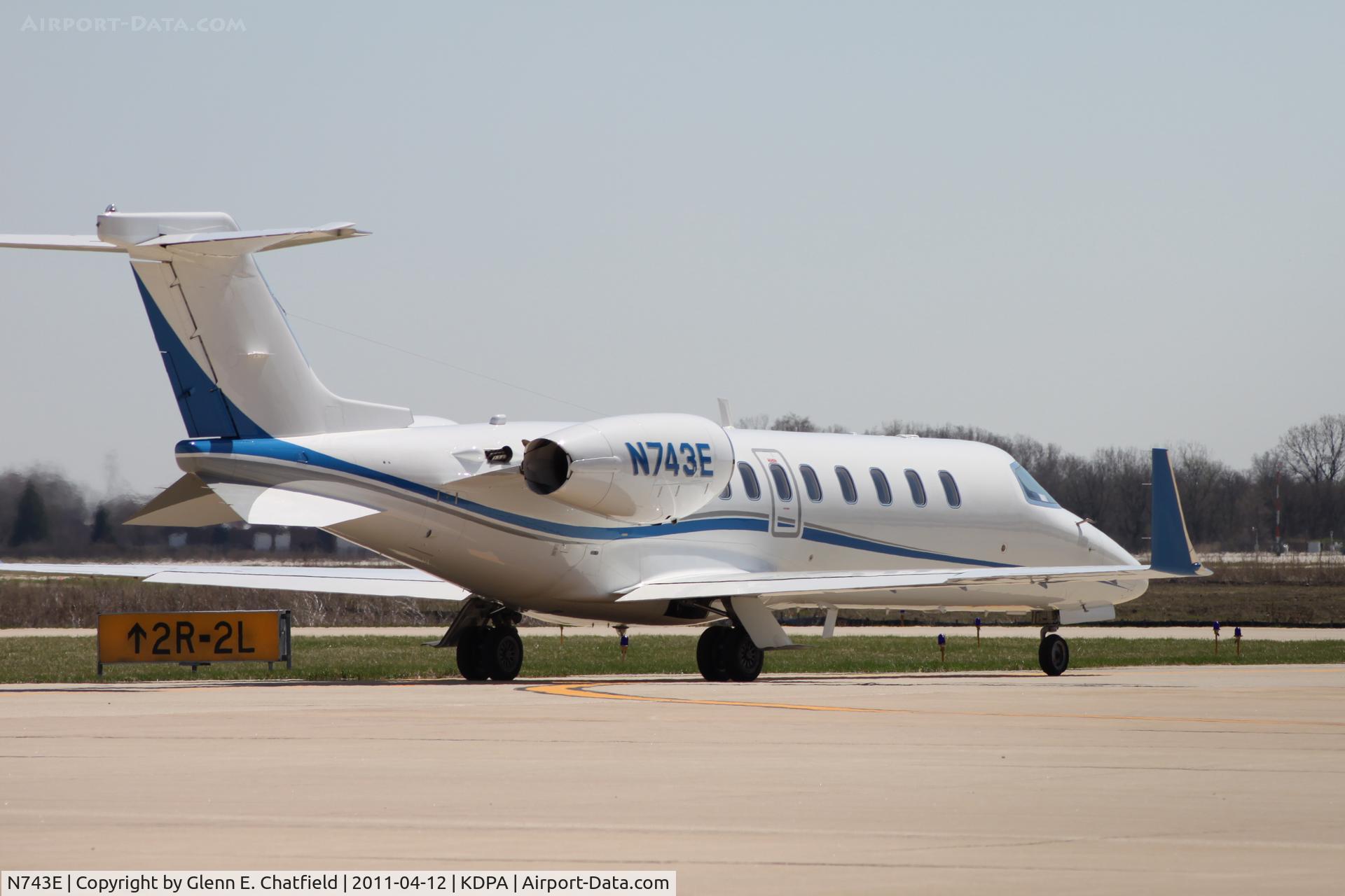 N743E, 2008 Learjet Inc 45 C/N 370, Taxiing to Runway 2L.  Photographed through a chain-link fence.