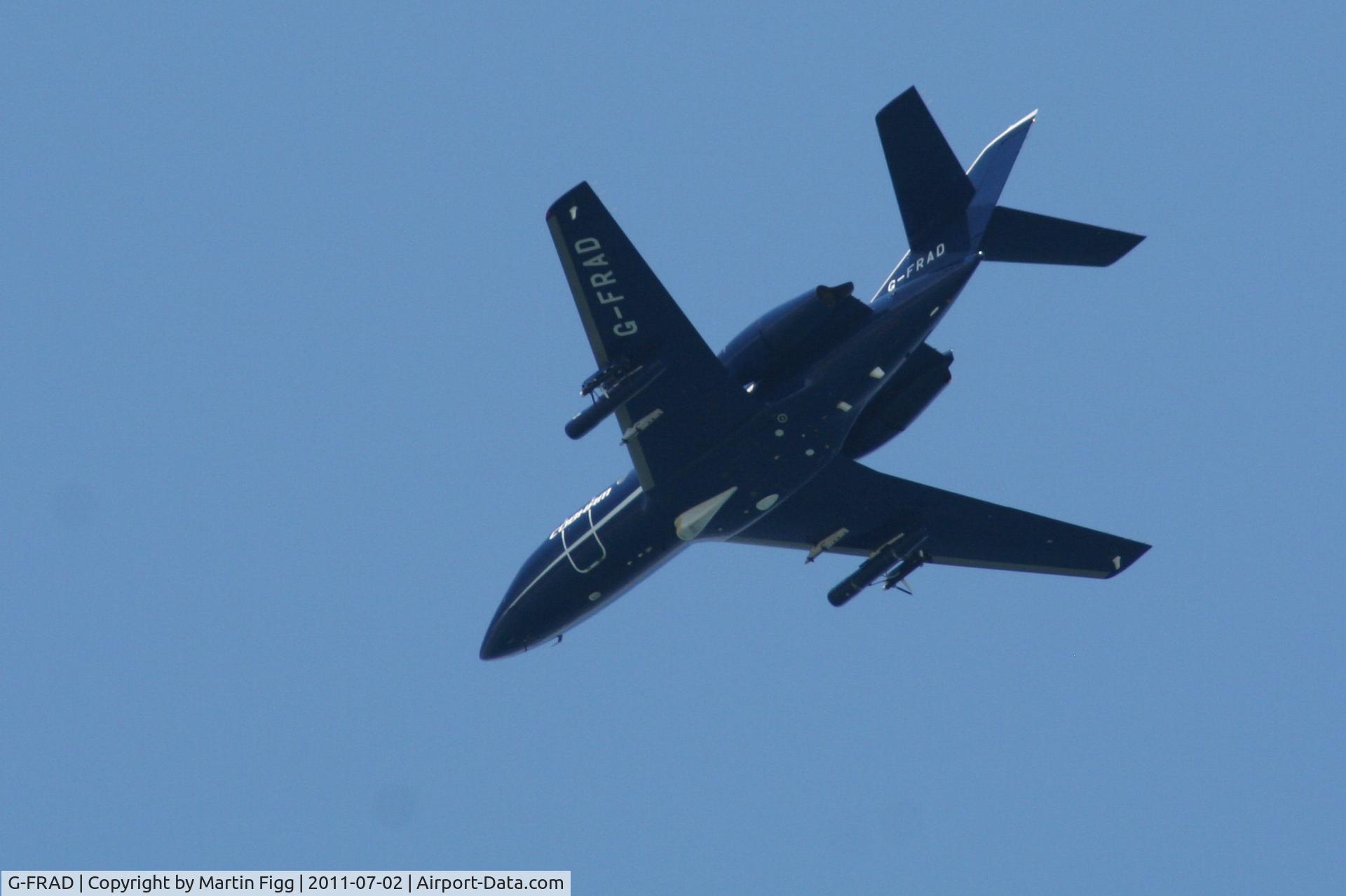 G-FRAD, 1975 Dassault Falcon (Mystere) 20DC C/N 304, Over Weymouth Bay under a clear sky. What's the under-wing equipment?
