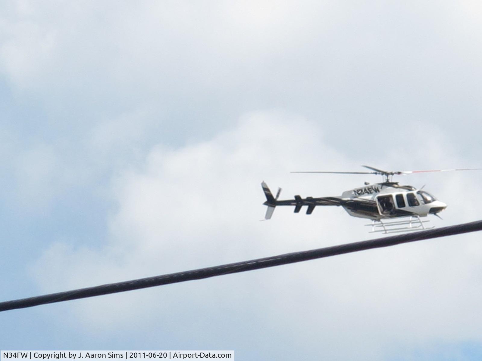 N34FW, 2001 Bell 407 C/N 53490, Took a picture while it was flying over downtown Birmingham.   It flew several circles over the railroad park area flew off, returned, then flew away.