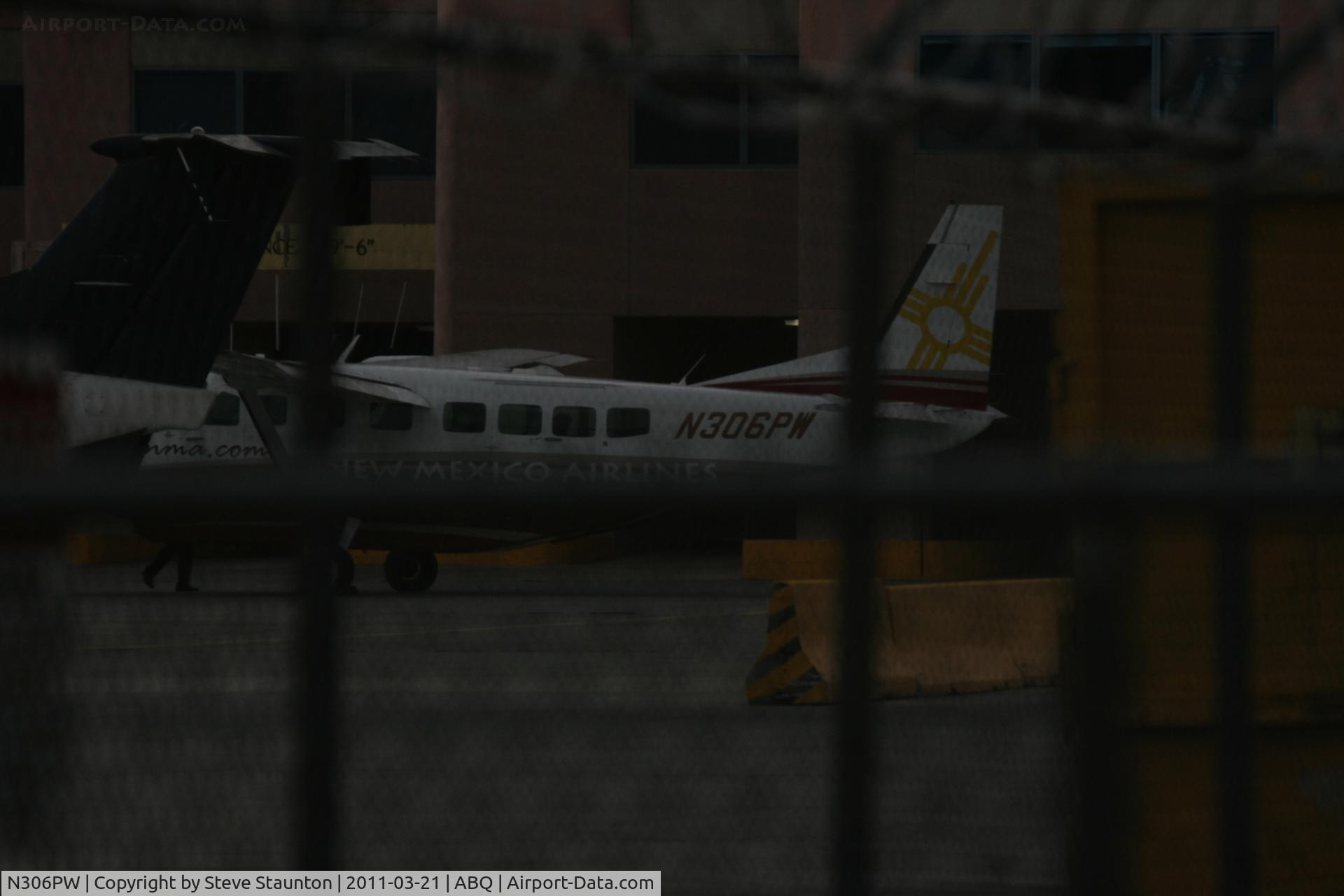 N306PW, 2007 Cessna 208B Grand Caravan C/N 208B1240, Taken at Alburquerque International Sunport Airport, New Mexico in March 2011 whilst on an Aeroprint Aviation tour - hiding behind a chain link fence in the gathering gloom