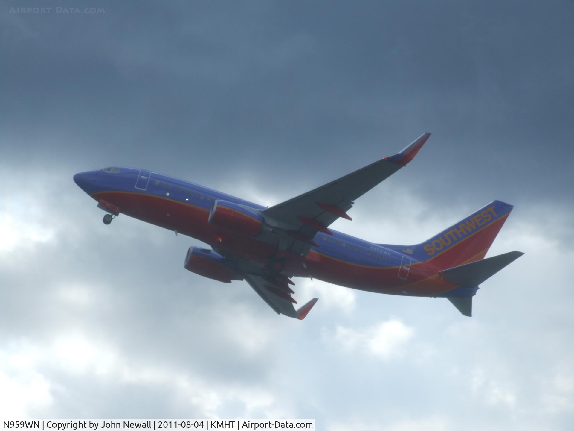 N959WN, 2011 Boeing 737-7H4 C/N 36674, take off from runway 17 with some angry weather around