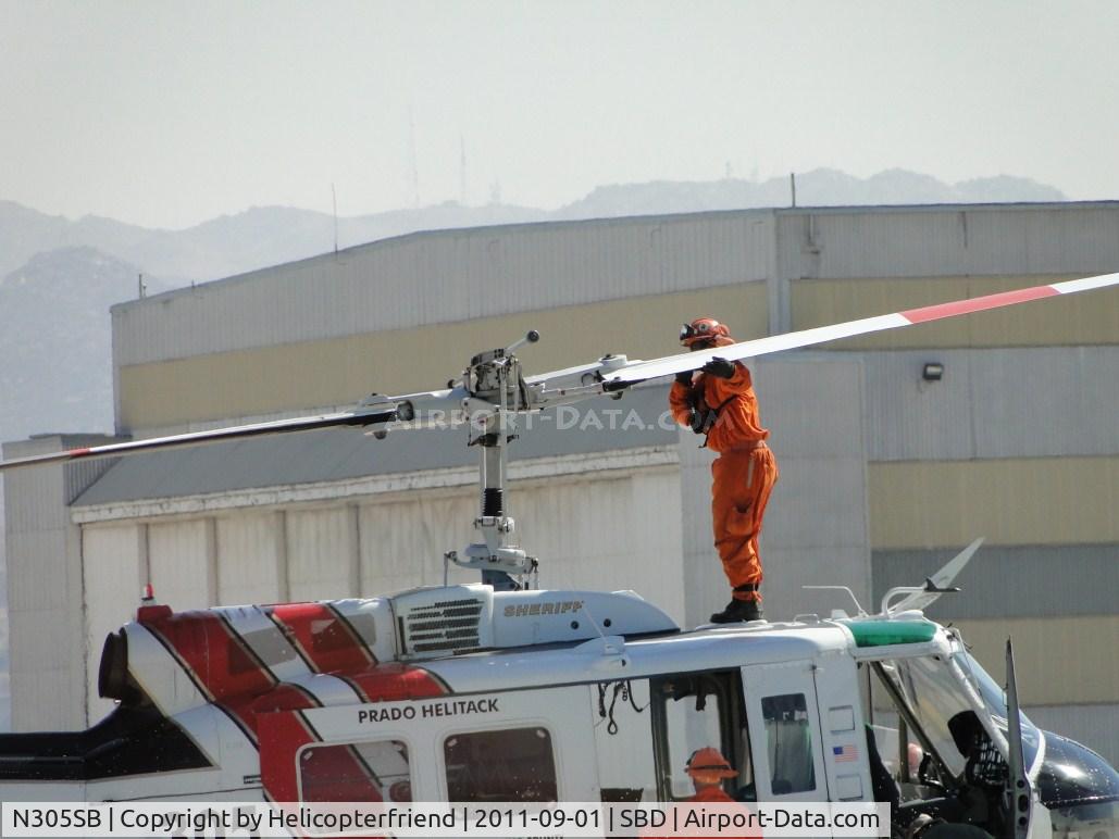 N305SB, 1969 Bell UH-1H-BF Iroquois C/N 11527, Just landed at US Forestry area and after shutting down, party climbed onto the cabin to help push the rear portion of the main rotor down for tying it off