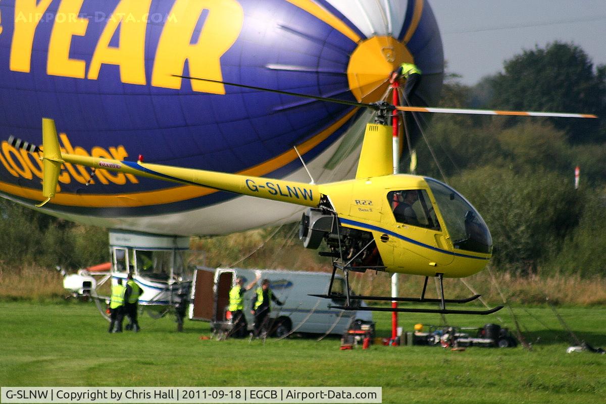 G-SLNW, 2003 Robinson R22 Beta II C/N 3524, R22 in a taxi hover past the Goodyear Airship