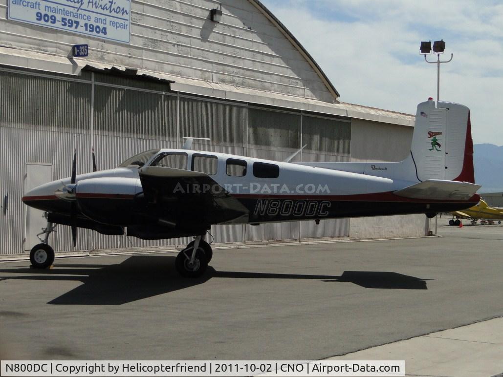 N800DC, 1956 Beech D50 Twin Bonanza C/N DH-120, Superfrog is parked near a hanger