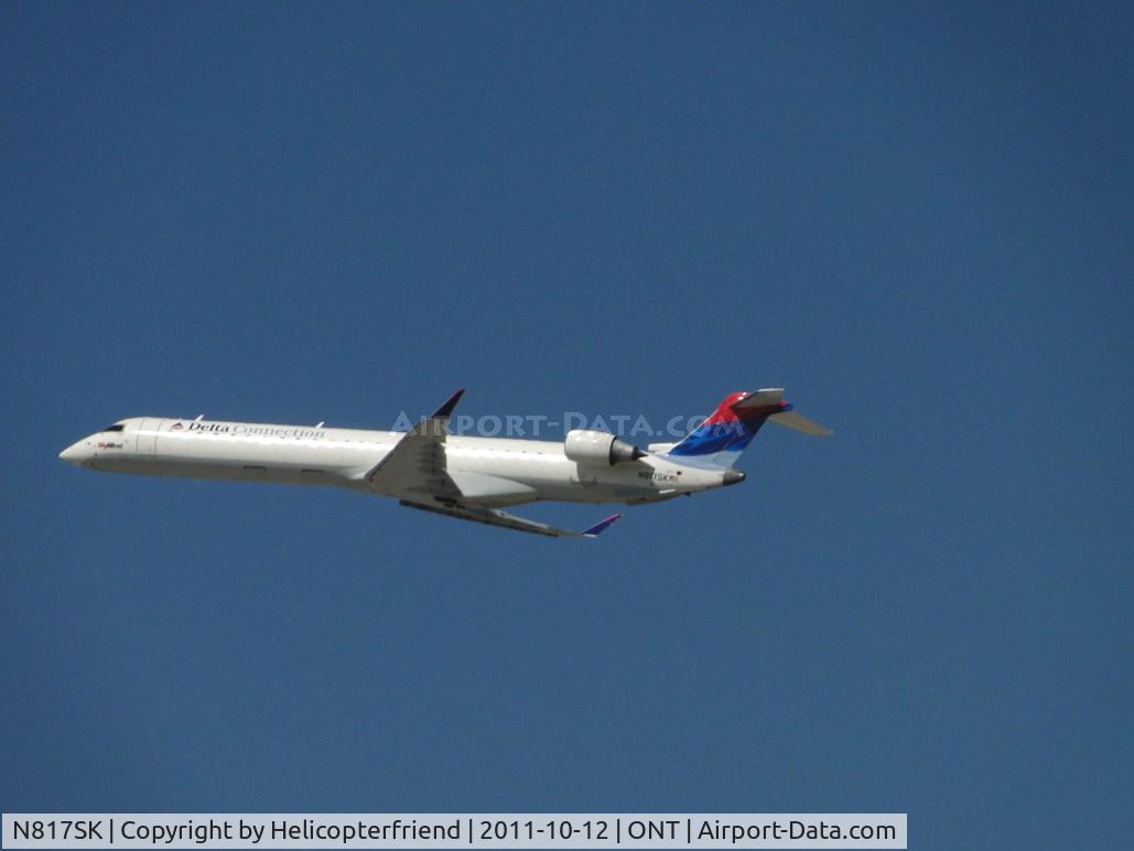 N817SK, 2006 Bombardier CRJ-900ER (CL-600-2D24) C/N 15107, Airbourne westbound from Runway 26R
