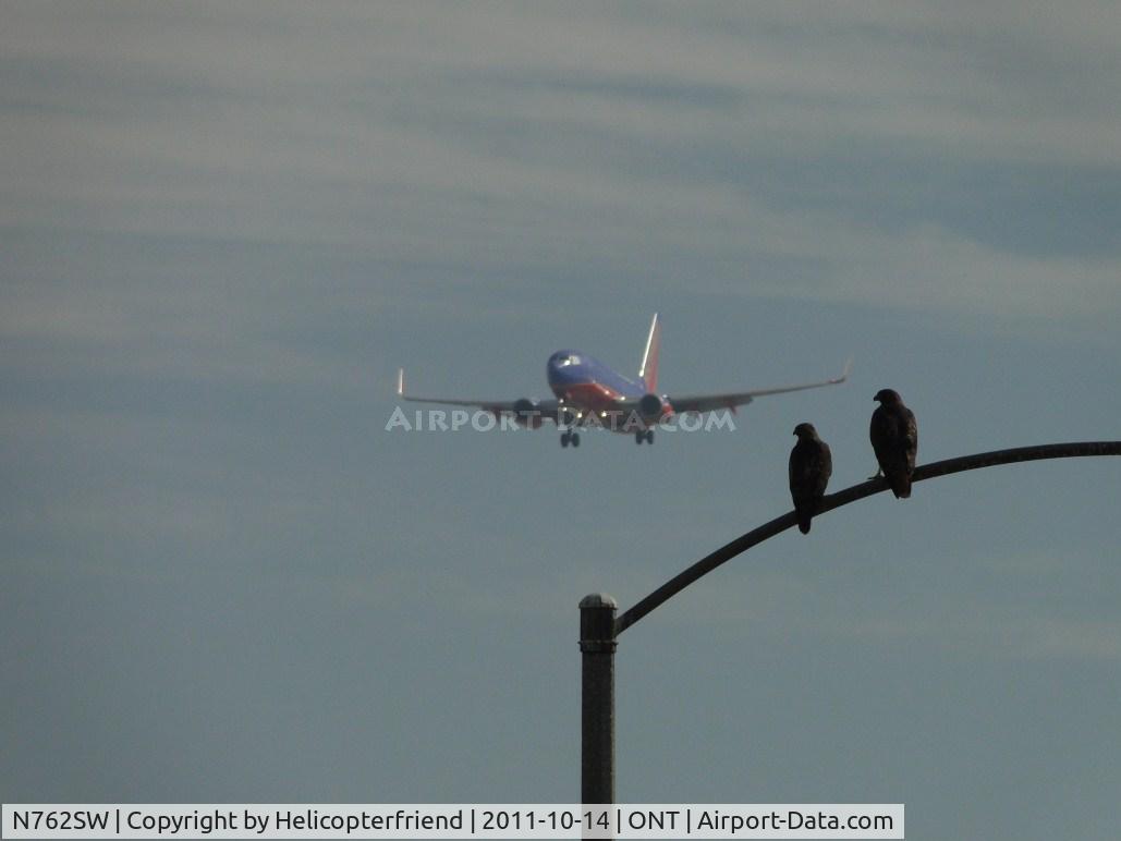 N762SW, 2000 Boeing 737-7H4 C/N 27876, Two friends are watching the ship on final to runway 26, probably thinking about how big that bird is