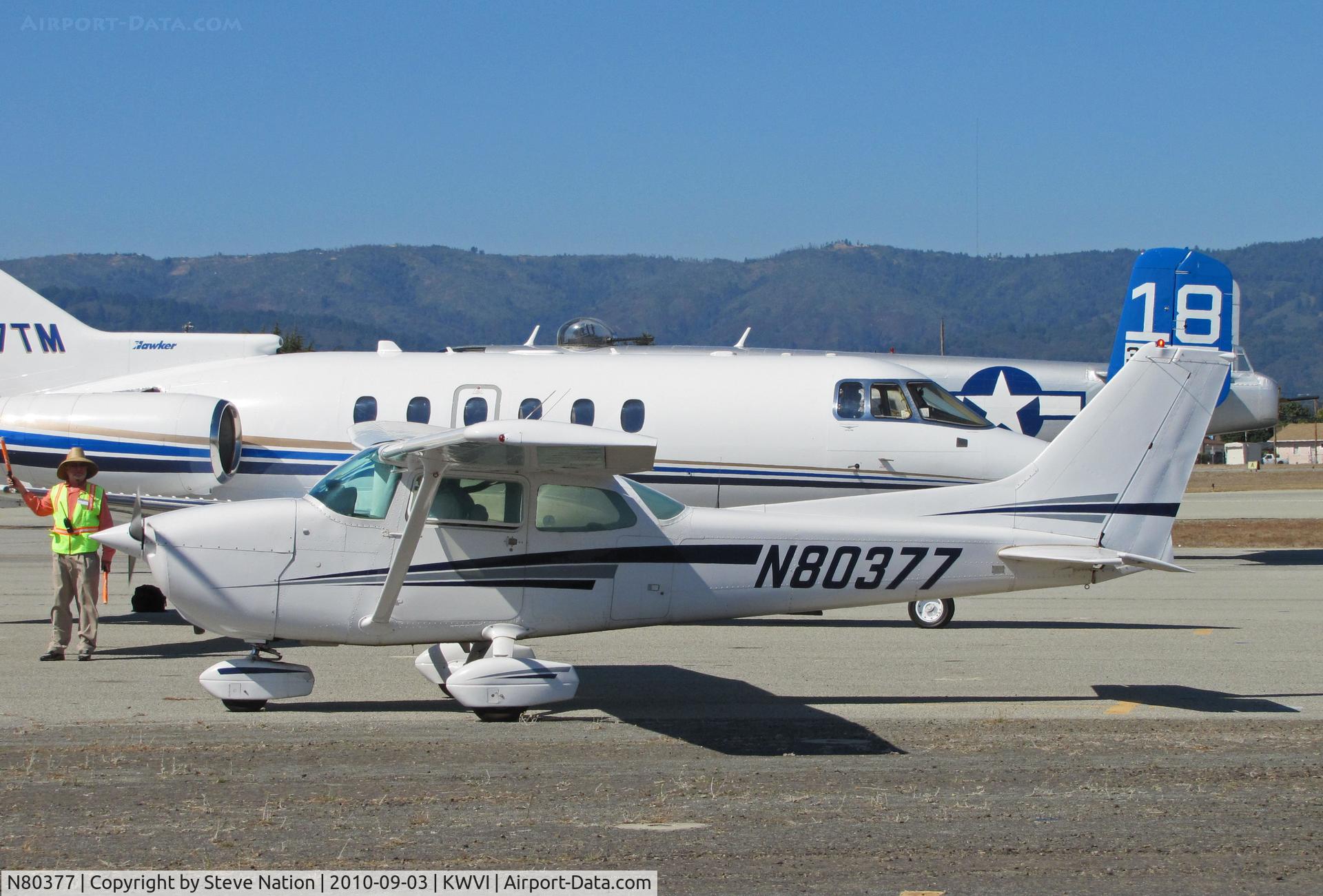 N80377, 1976 Cessna 172M C/N 17266559, Seagull Flying Club (Sunnyvale, CA) 1976 Cessna 172M taxiing @ Watsonville Fly-In (with Hawker 800XP and B-25J/18 in background)