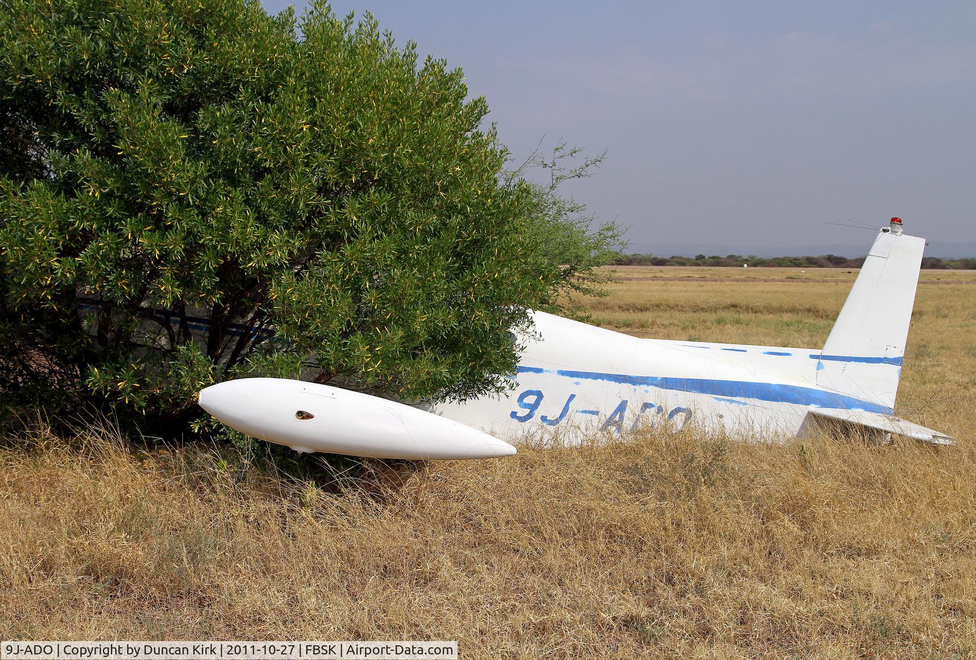 9J-ADO, SIAI-Marchetti S-208 C/N 2-23, This has been dumped at Gaborone, Botswana long enough for a tree to grow around it!