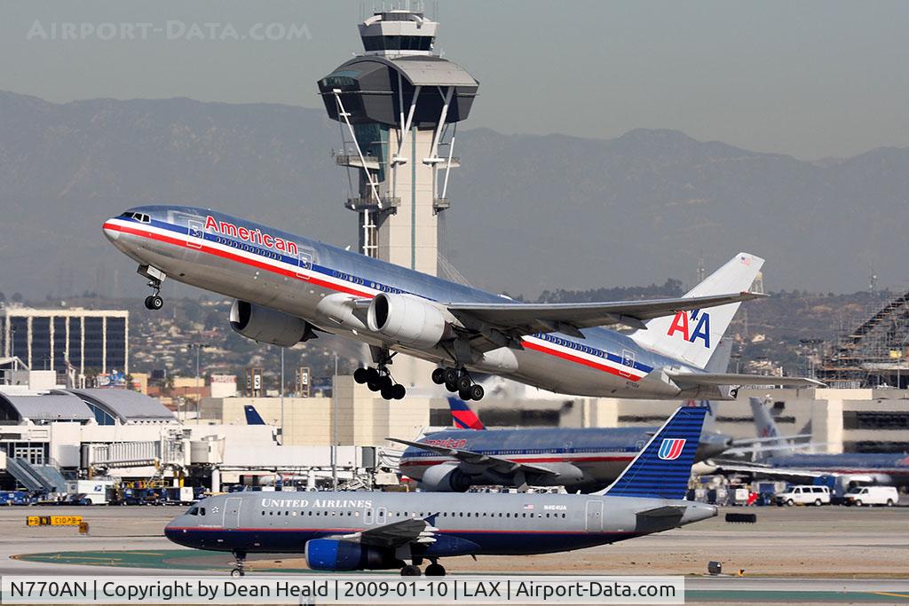 N770AN, 1999 Boeing 777-223 C/N 29578, American Airlines N770AN departing RWY 25R with United Airlines N464UA holding short after arrival on RWY 25L.
