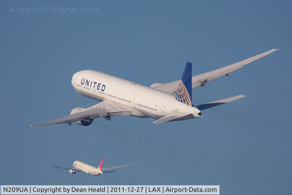 N209UA, 1999 Boeing 777-222 C/N 30215, United Airlines N209UA (FLT UAL891) climbing out from RWY 25R en route to Tokyo Narita Int'l (RJAA/NRT), while JAL61 climbs out from the North Complex en route to the same destination.